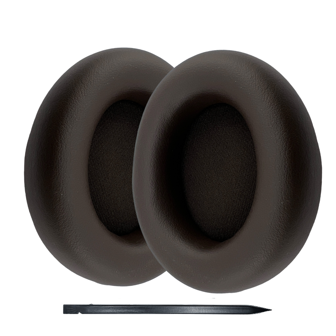 Pair of black earpad replacements with a pen for scale on a white background