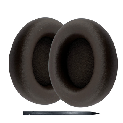Pair of black earpad replacements with a pen for scale on a white background