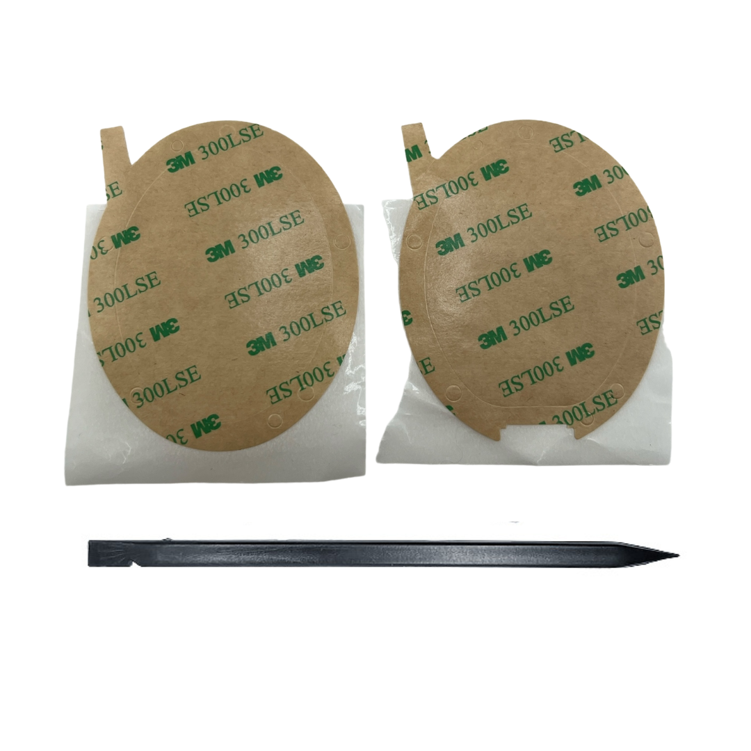 Two round adhesive patches with 3M tape on a white background, accompanied by a black tool.